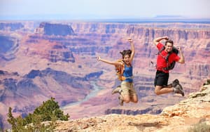 Two people jumping in front of the Grand Canyon